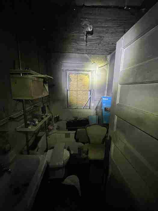 Dark, cluttered bathroom with broken window.