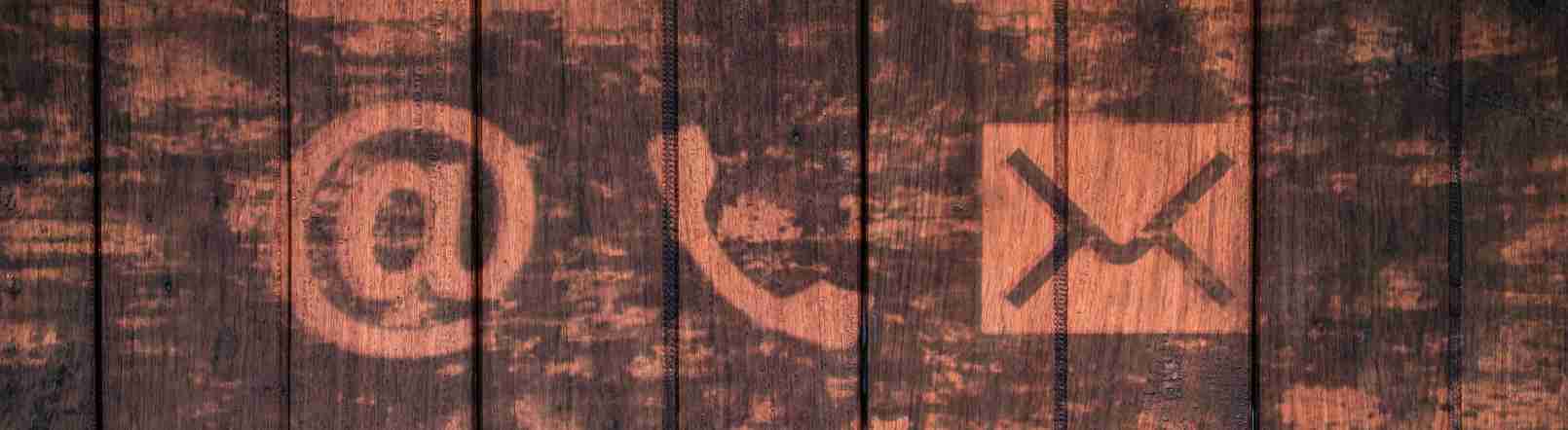 Contact icons on rustic wooden background.